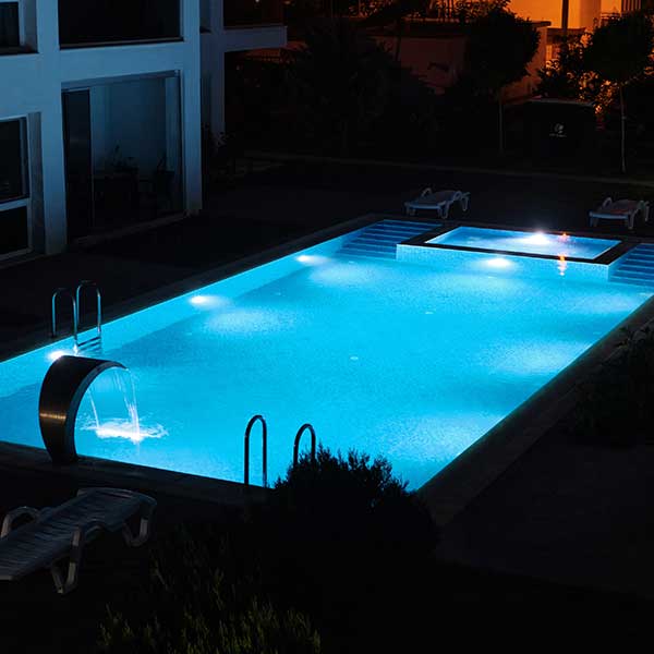 Piscine de nuit éclairée en bleu clair